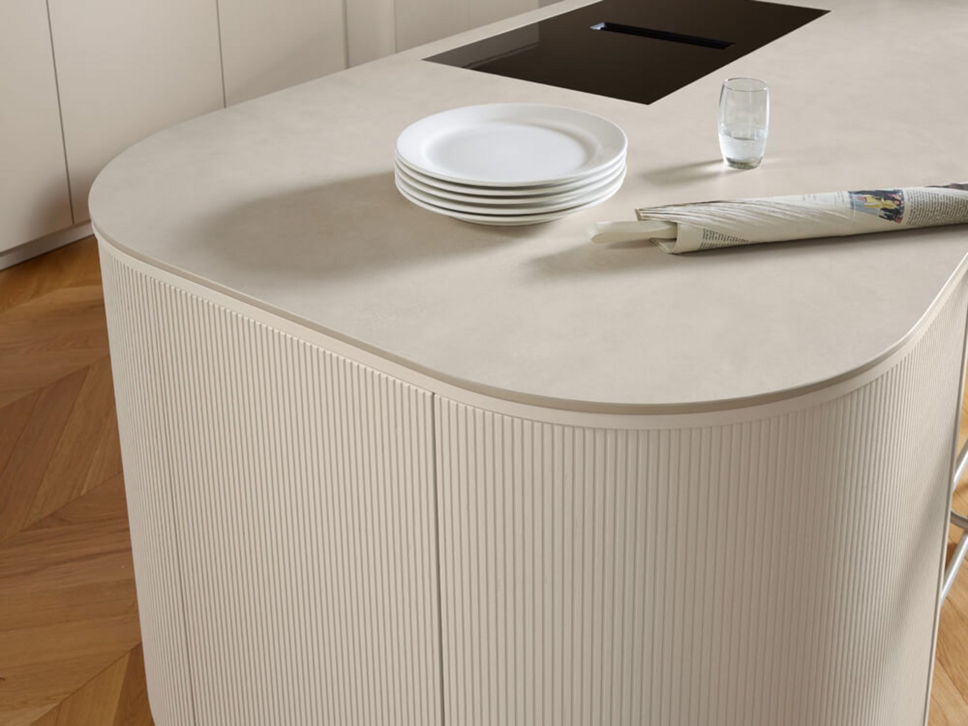 Grifflose Küche mit Insel, organischen Rundungen und fein gerillter Front in Eiche Angora grau.