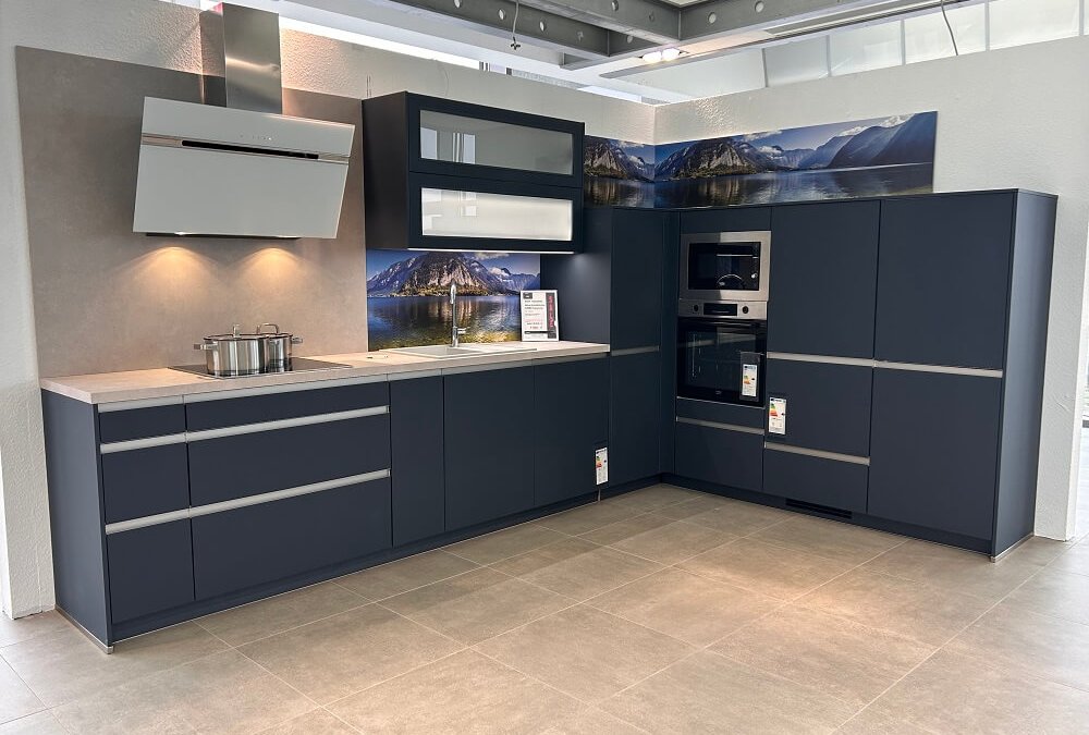 L-Küche Easy Line 44b in Fjordblau mit Glasrückwand und modernen Hängeschränken – Ausstellung bei ASMO KÜCHEN Freiham