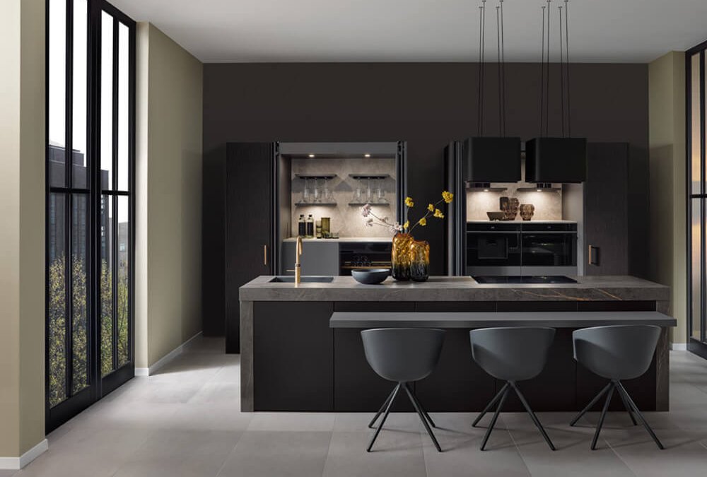 Schwarze Luxusküche mit Pocket-Doors und beleuchtetem Bar-Element in einer grifflosen Planung.