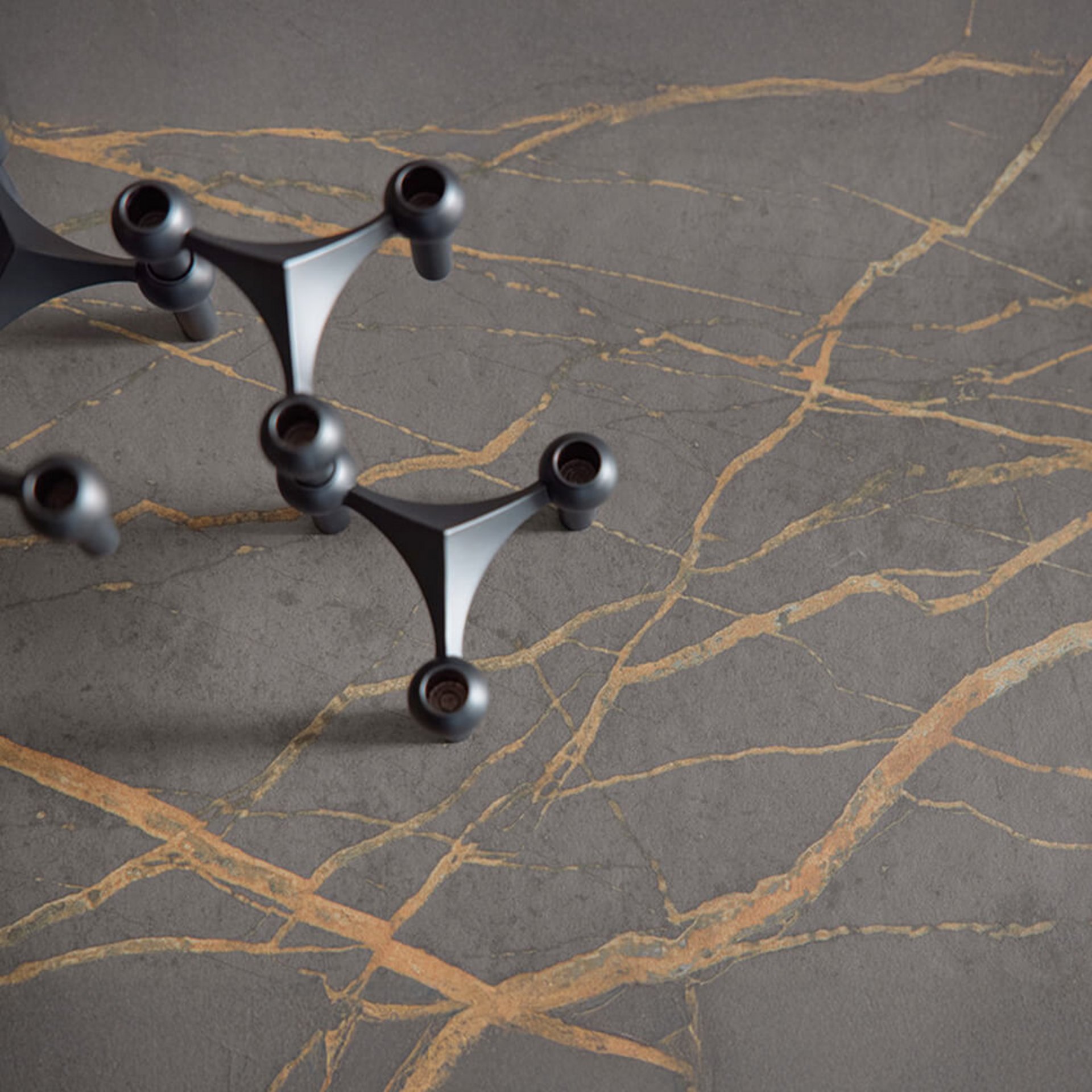 Steinoberfläche mit goldfarbenen Adern und Armaturdetail – natürliche Materialwirkung mit markanter Struktur