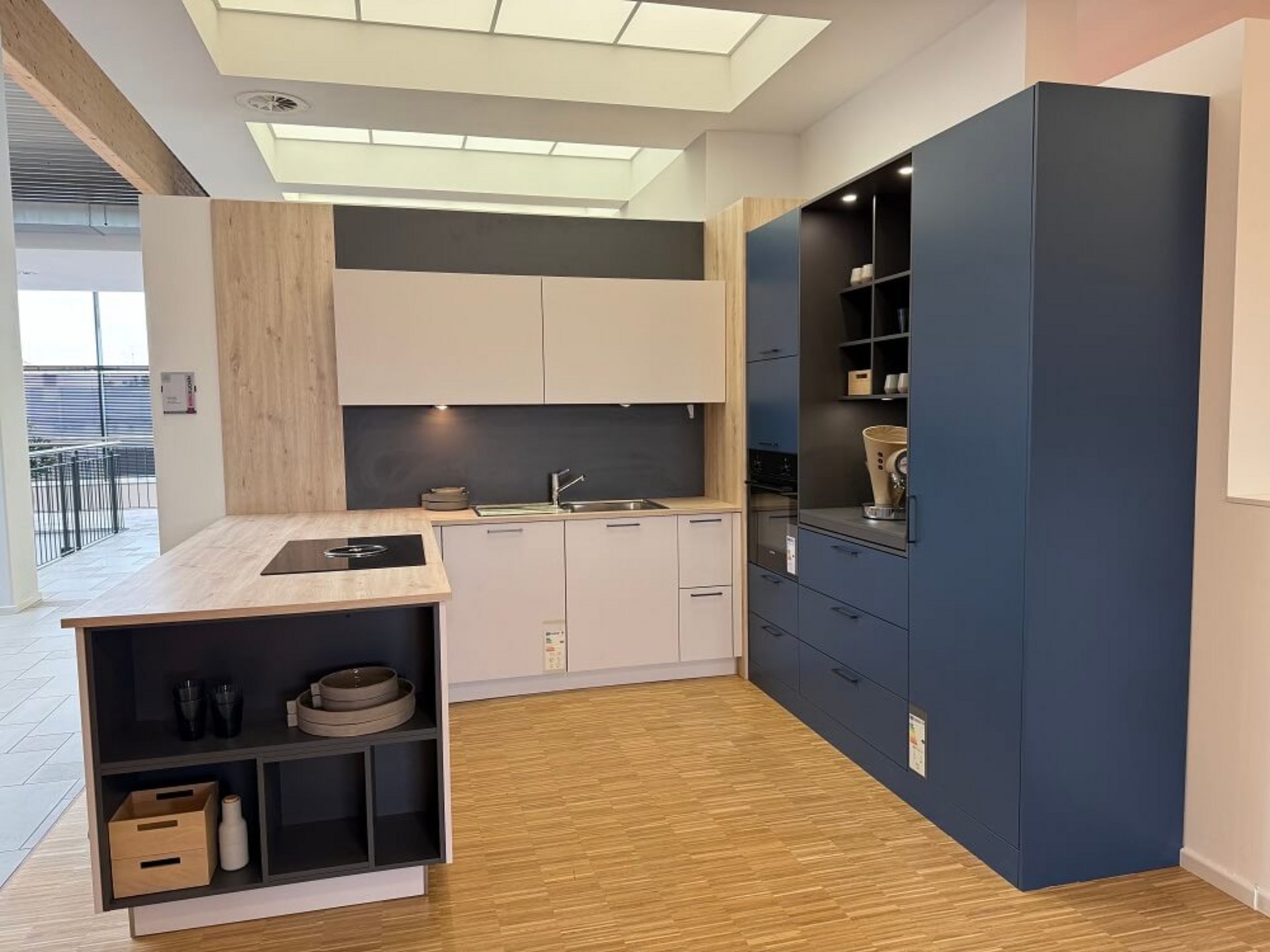 Moderne U-Küche in Weiß mit blauen Hochschränken und Holzdetails