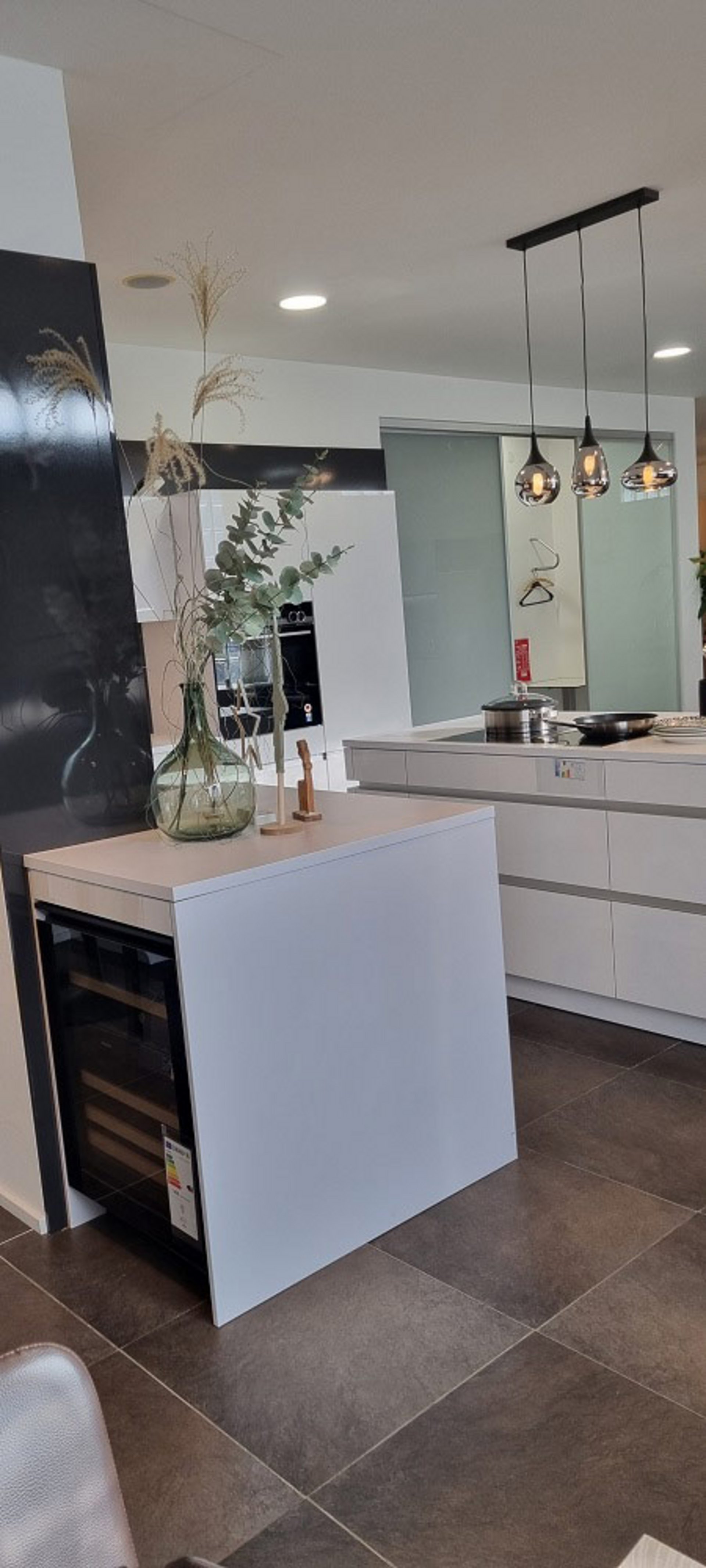 Moderne LEICHT L-Küche in Arktis glänzend mit großzügiger Kochinsel, Induktionskochfeld und viel Arbeitsfläche im Küchenstudio Landshut.