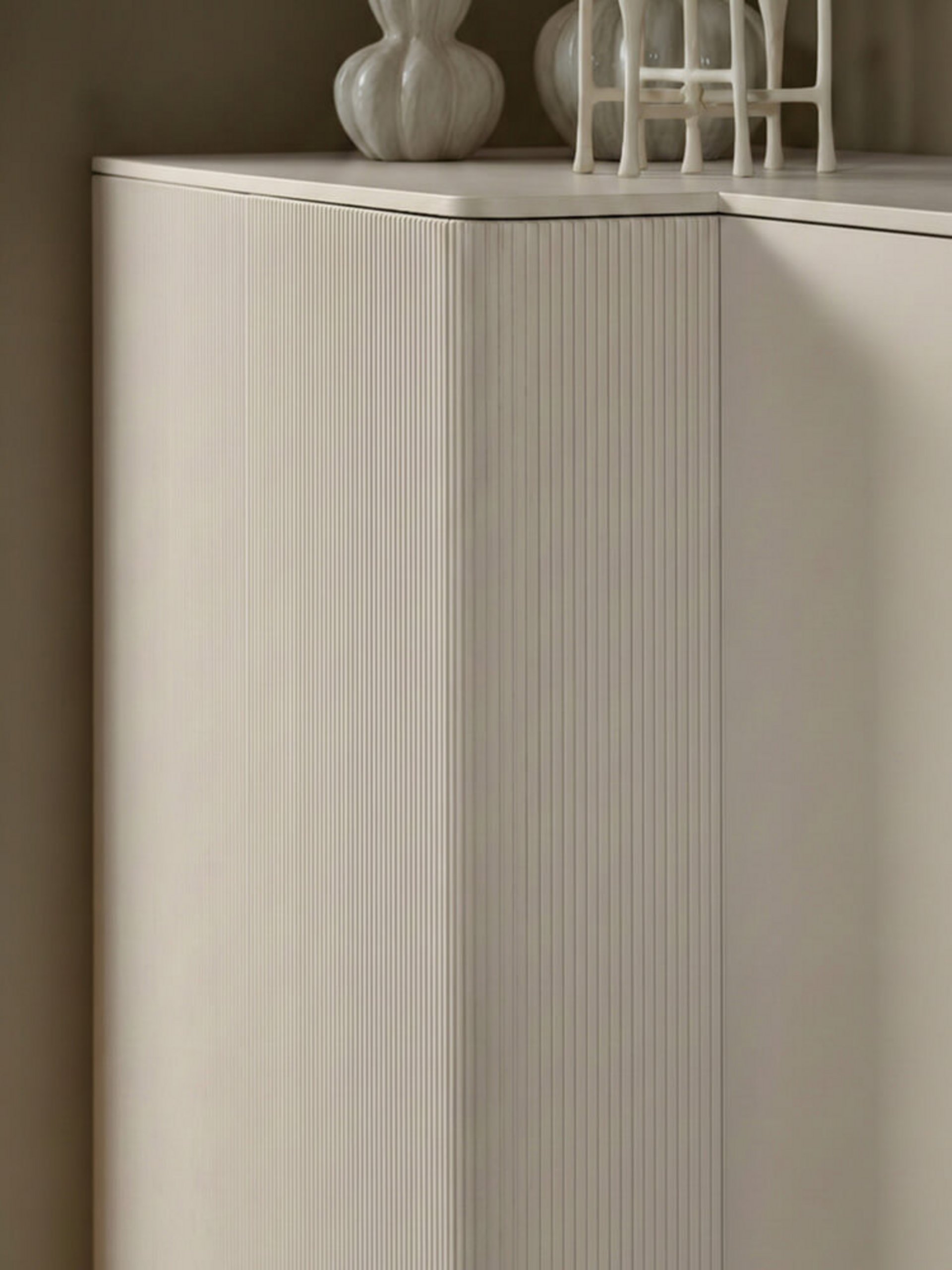 Modulares Küchendesign mit organischen Rundungen und vertikaler Rillenoptik am Midischrank aus Echtholz.