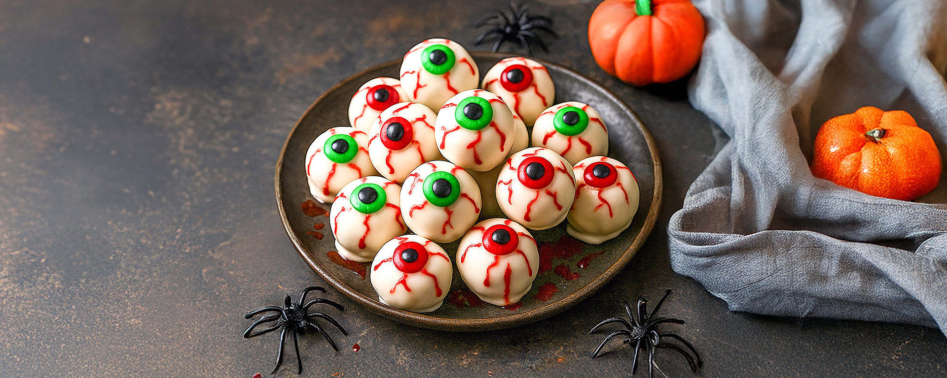 Monster-Augen-Trüffel – gruselige Halloween-Süßigkeiten mit weißer Schokolade auf einem Teller zum Selbermachen