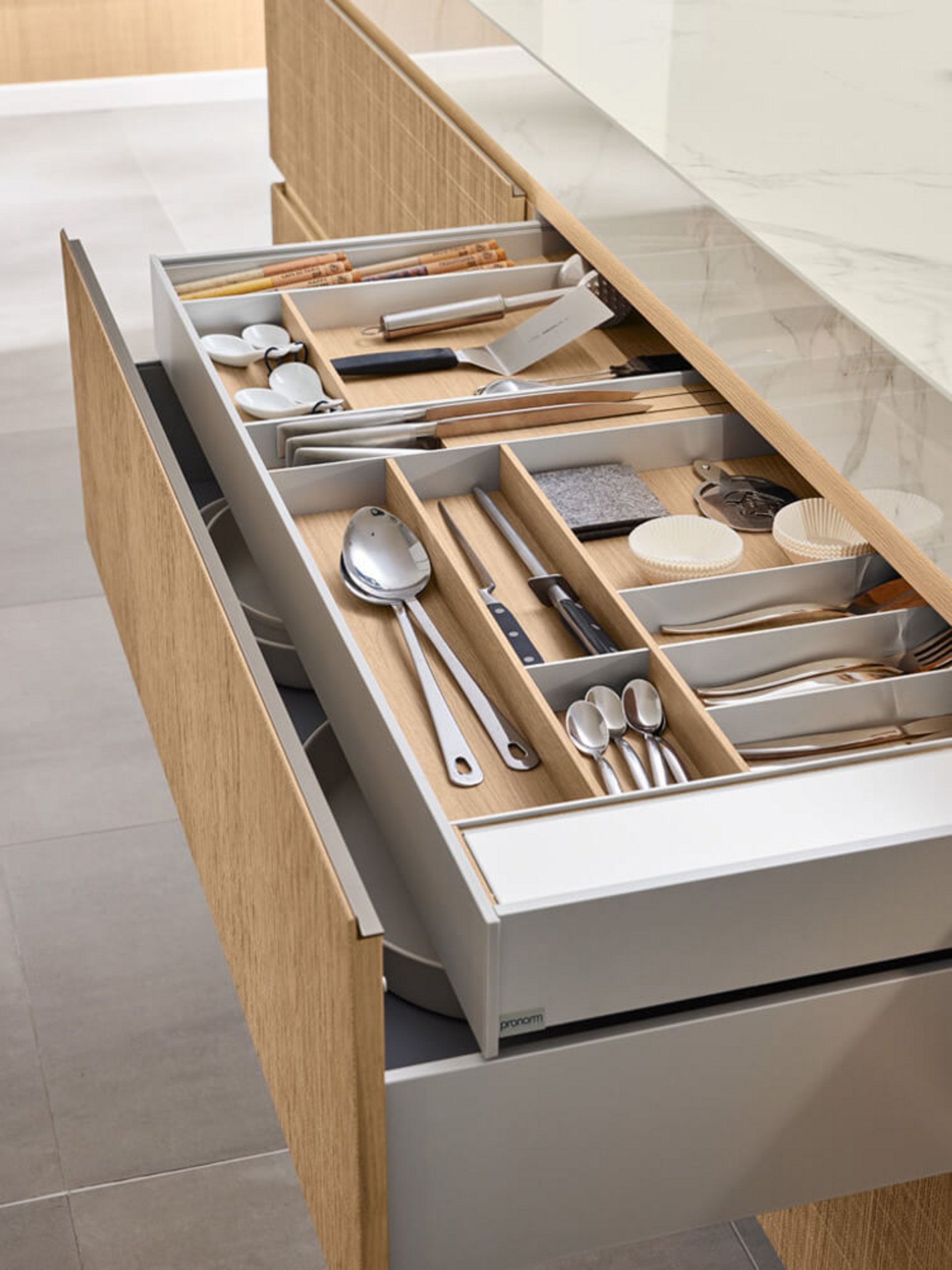 Besteckschublade mit Holzeinsatz und präziser Facheinteilung für eine übersichtliche Küchenorganisation.