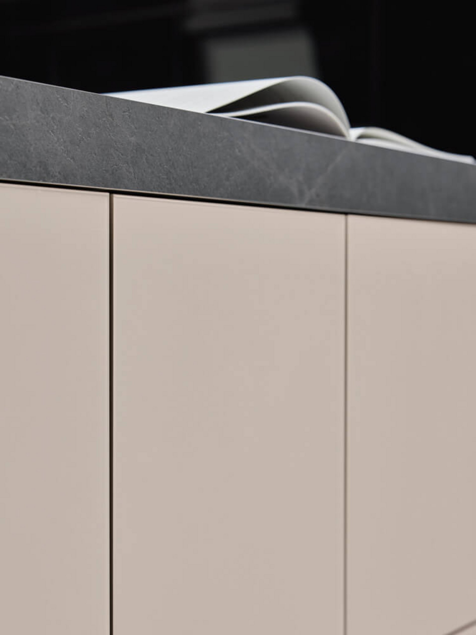 Grifflose Küchenfronten in Perlmutt-Dekor als Kontrast zu schwarzen Strukturfronten