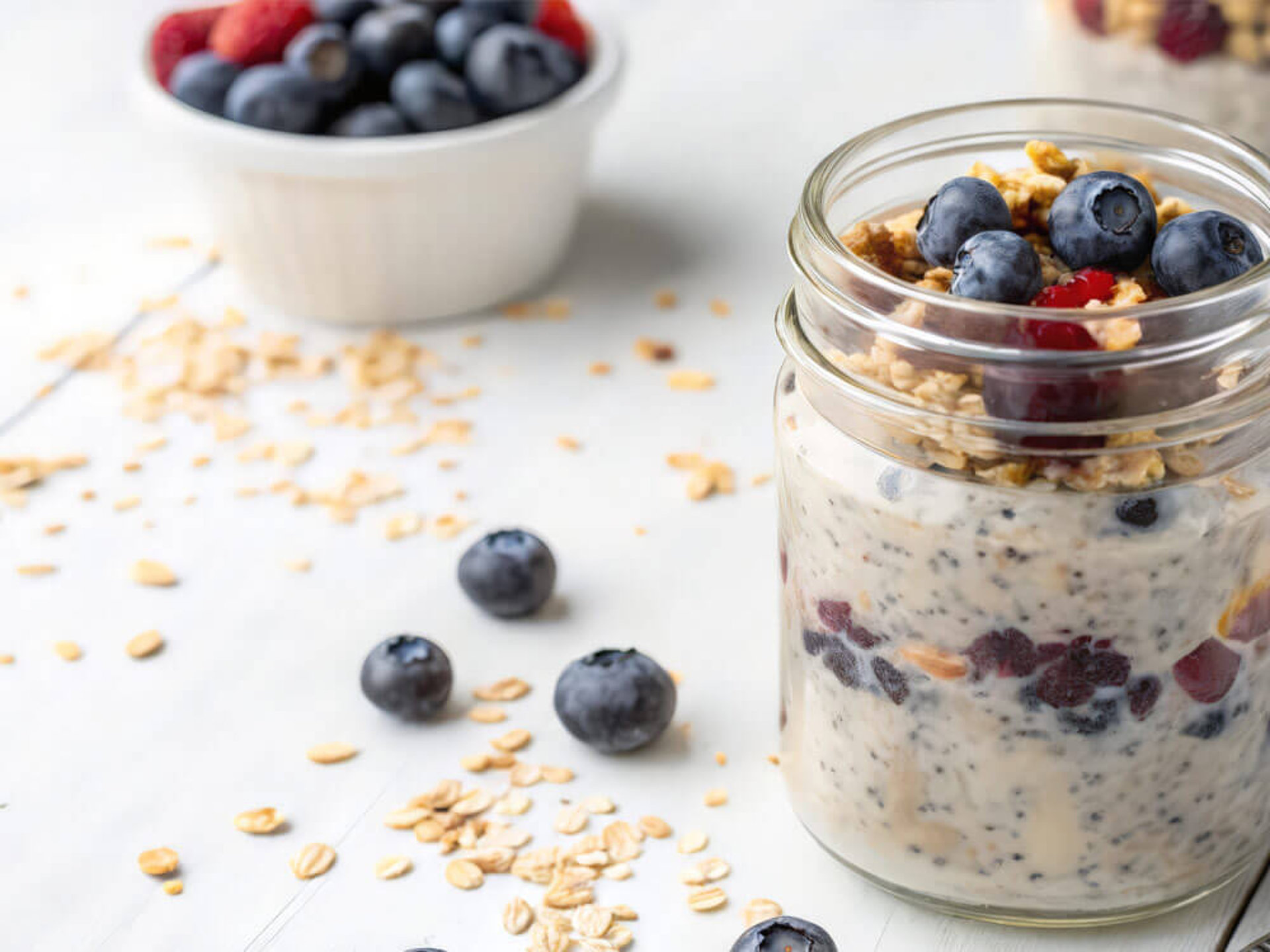Ein Glas mit Overnight Oats, Haferflocken und frischen Beeren, ein einfaches und ballaststoffreiches-Frühstück nach dem Fibremaxxing-Trend.