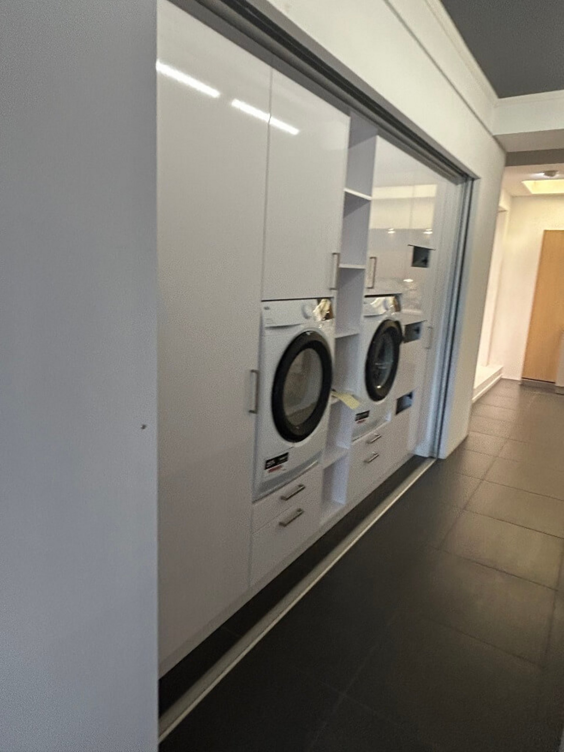 Moderner Hauswirtschaftsraum mit Waschmaschine, Trockner, Hochschränken und Stauraum bei ASMO KÜCHEN