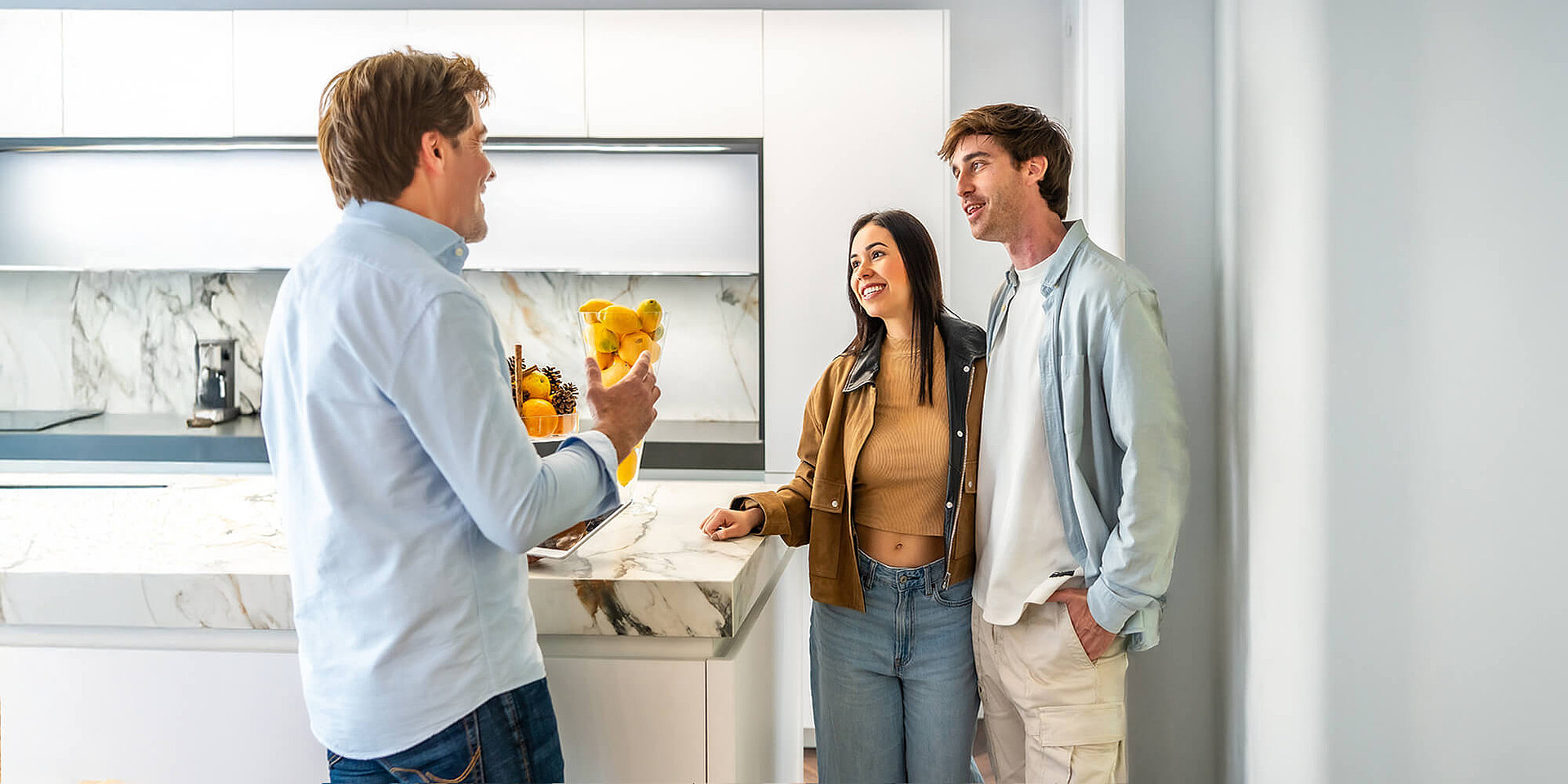 Küchenberater begrüßt glückliches Kundenpaar – Auszeichnung Deutschlands beste Kundenberater für ASMO KÜCHEN (F.A.Z.-Institut)