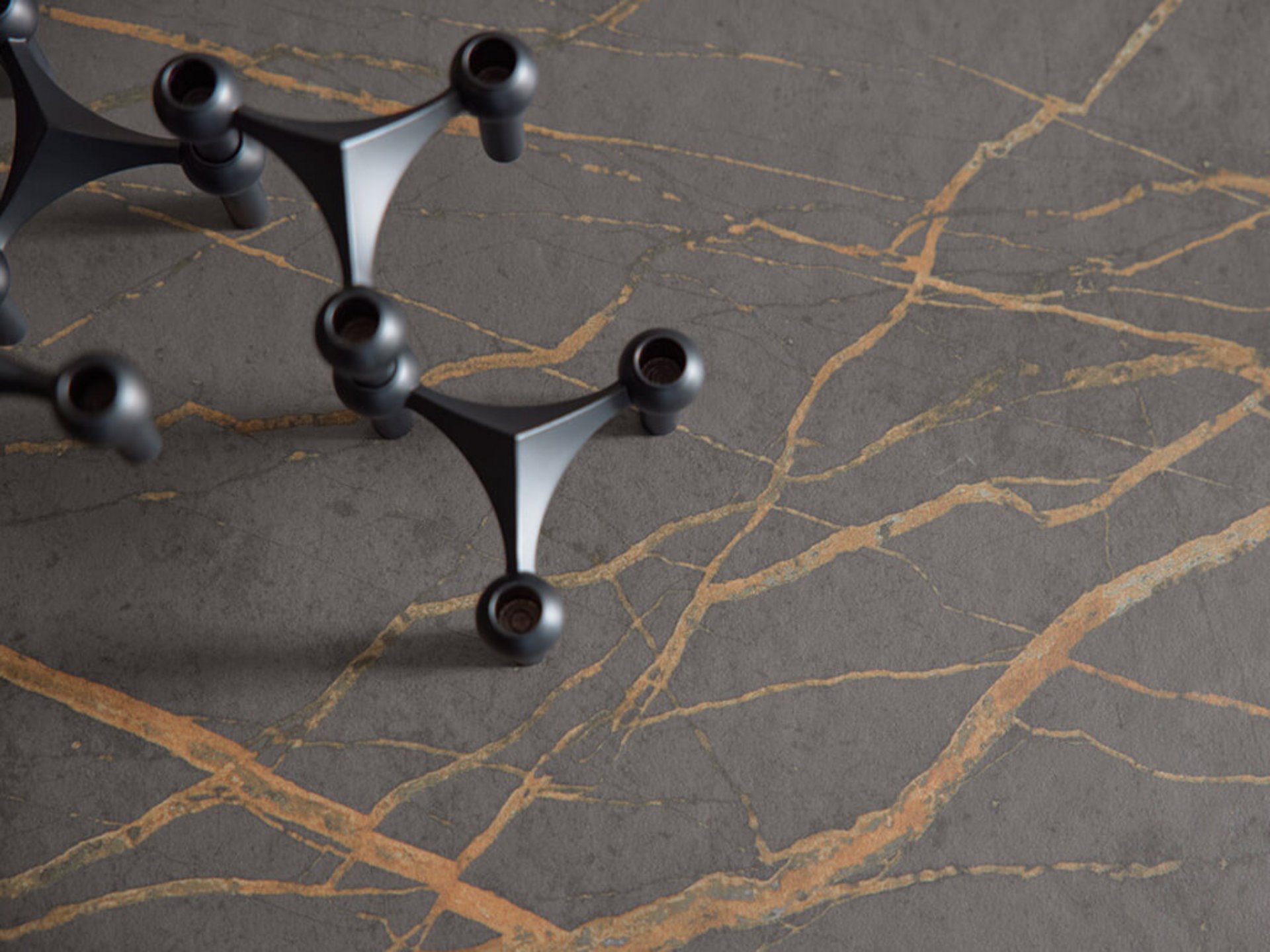 Arbeitsplatte in Steinoptik mit Goldadern auf einer dunklen Kücheninsel der Serie Y-OS organic Bernstein schwarz.