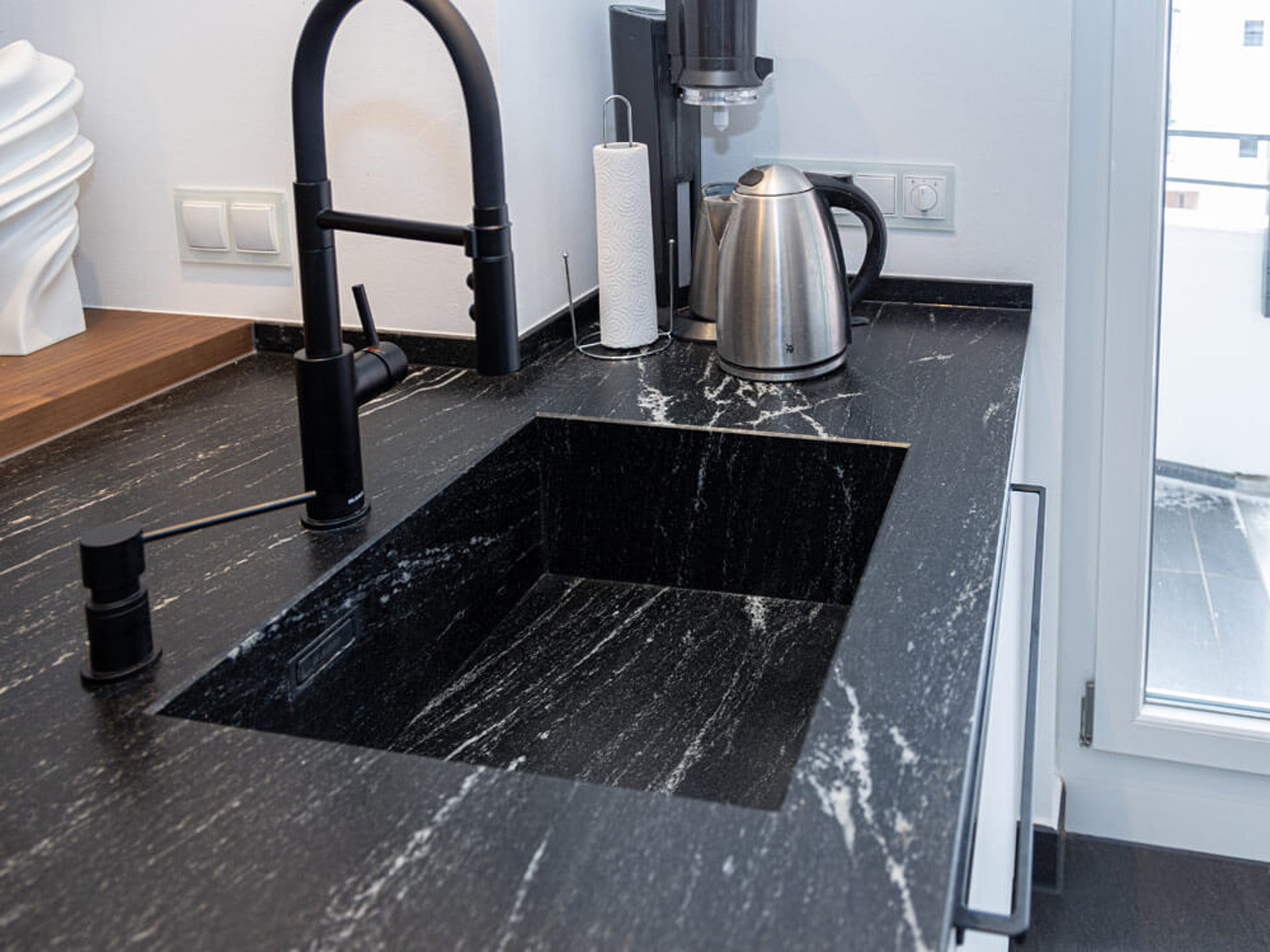 Personalisierte, ergonomische Küche mit tiefem Spülbecken und Wasserhahn, optimal für ergonomisches Arbeiten.