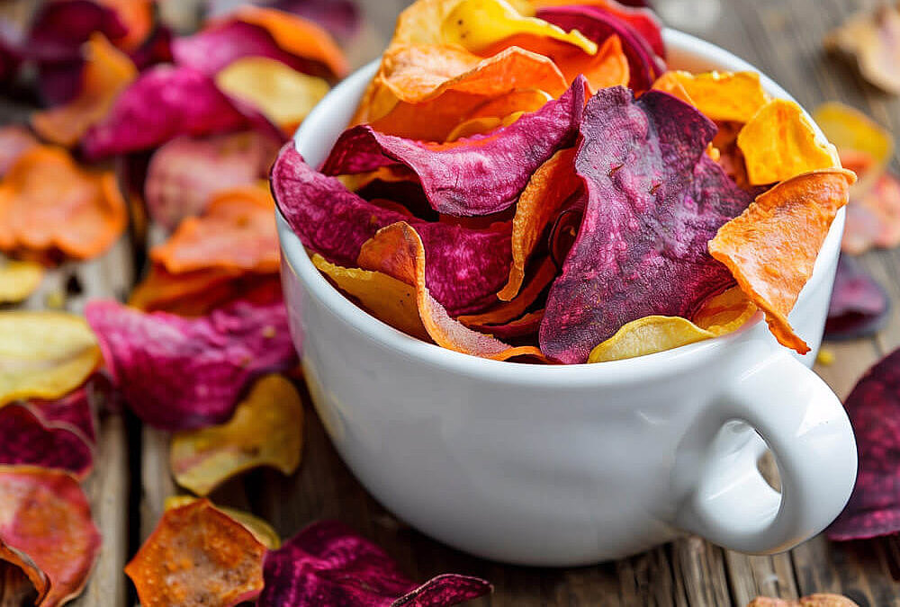 Bunte Gemüsechips selber machen – Rote-Bete- und Möhrenchips in weißer Tasse auf Holztisch