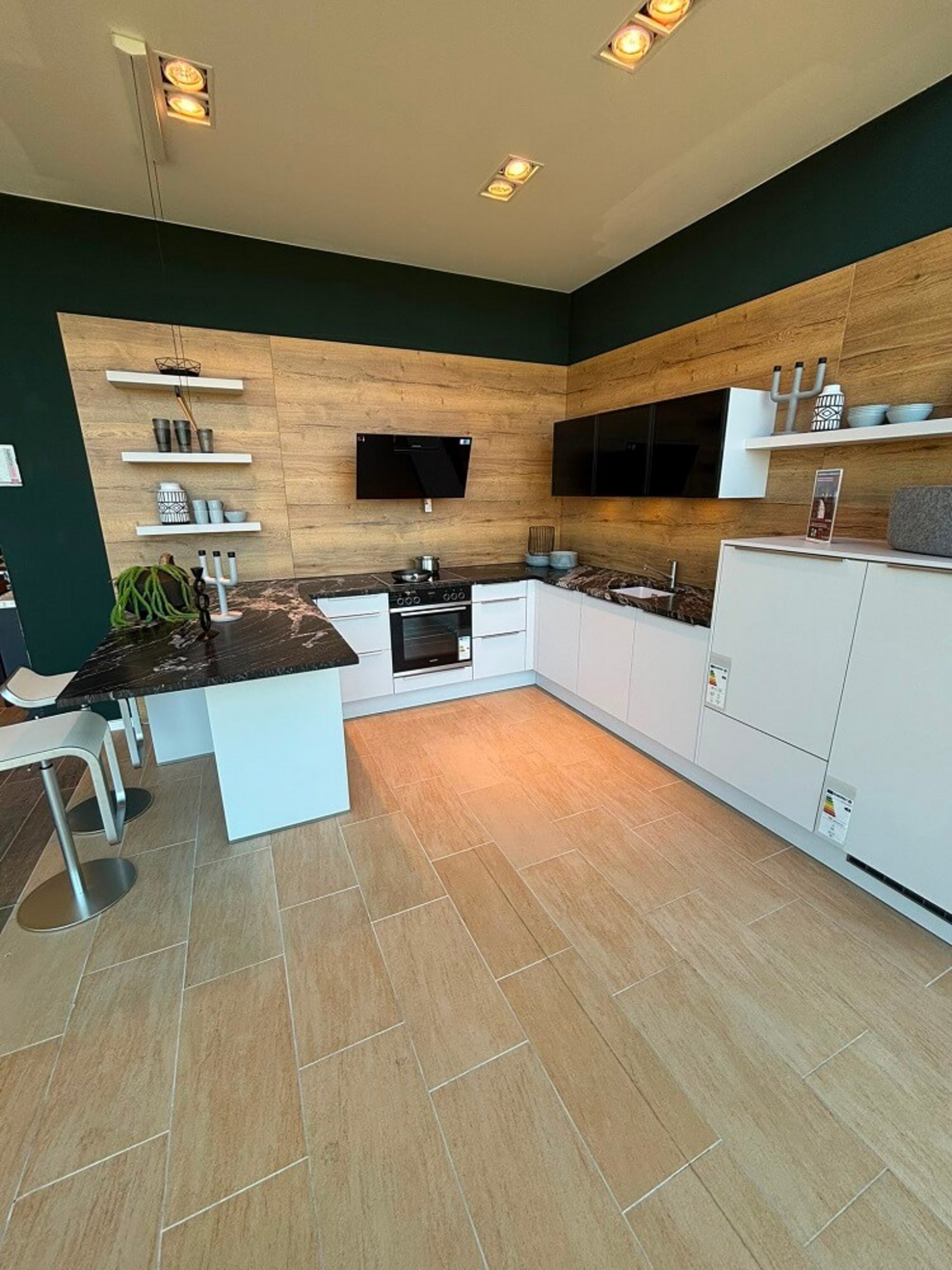 Moderne Kücheninsel mit kristallweißen Fronten, Holzoptik und großzügiger Arbeitsfläche in Unterhaching