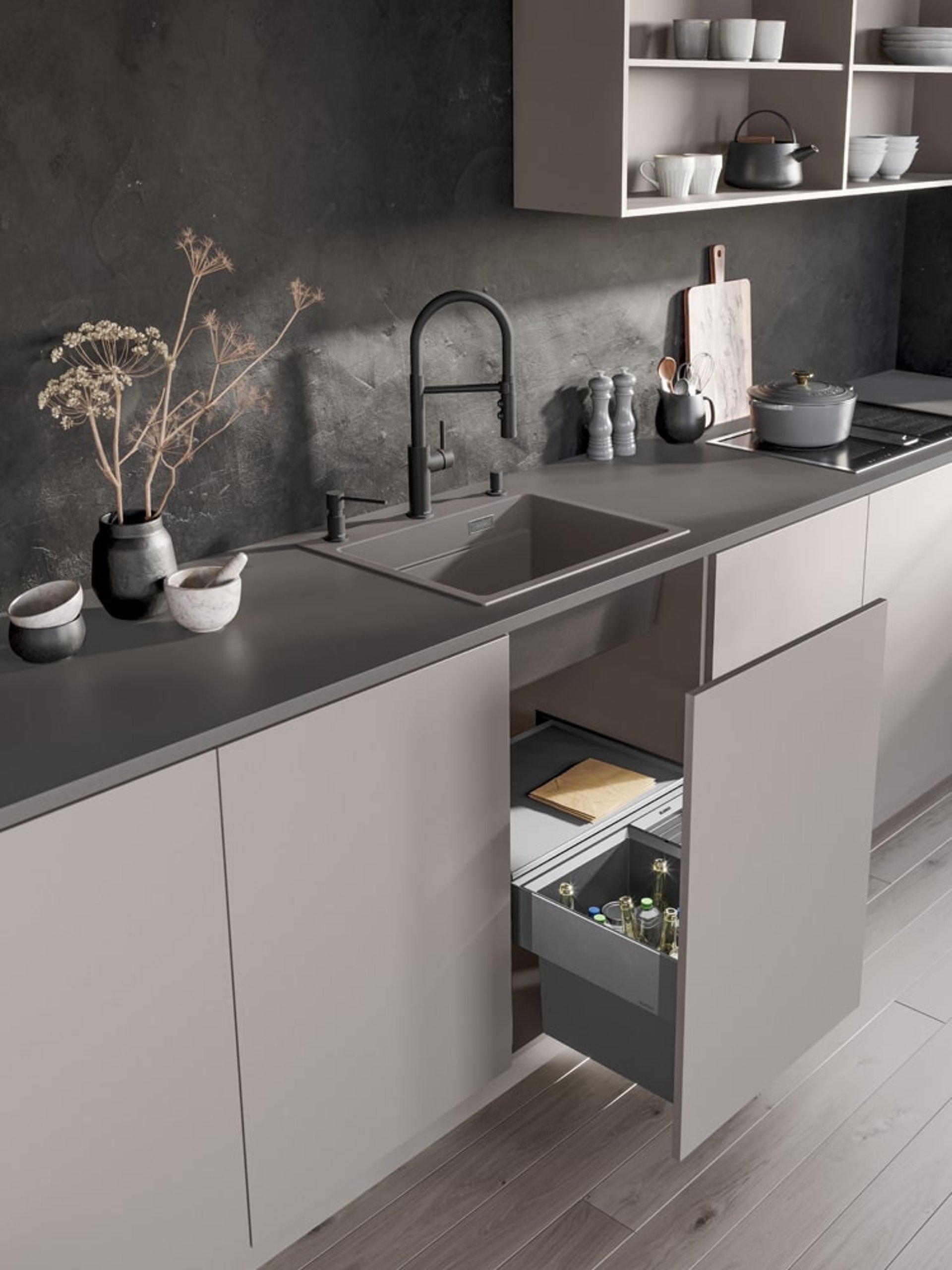 Modernes Küchenlayout mit Blanco Spüle und integriertem Mülltrennsystem unter der Arbeitsplatte. Stilvolle Abfalllösung.