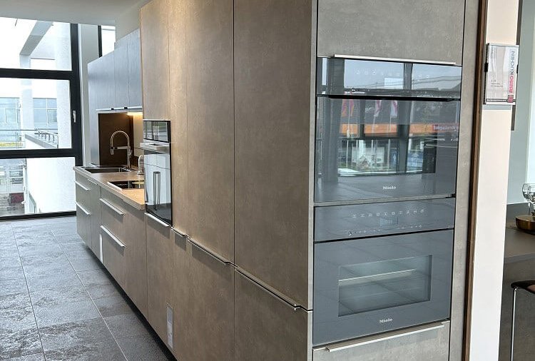 Moderne ASMO KÜCHEN Küchenzeile in Betonoptik mit Hochschränken, Backofen und integrierten Elektrogeräten
