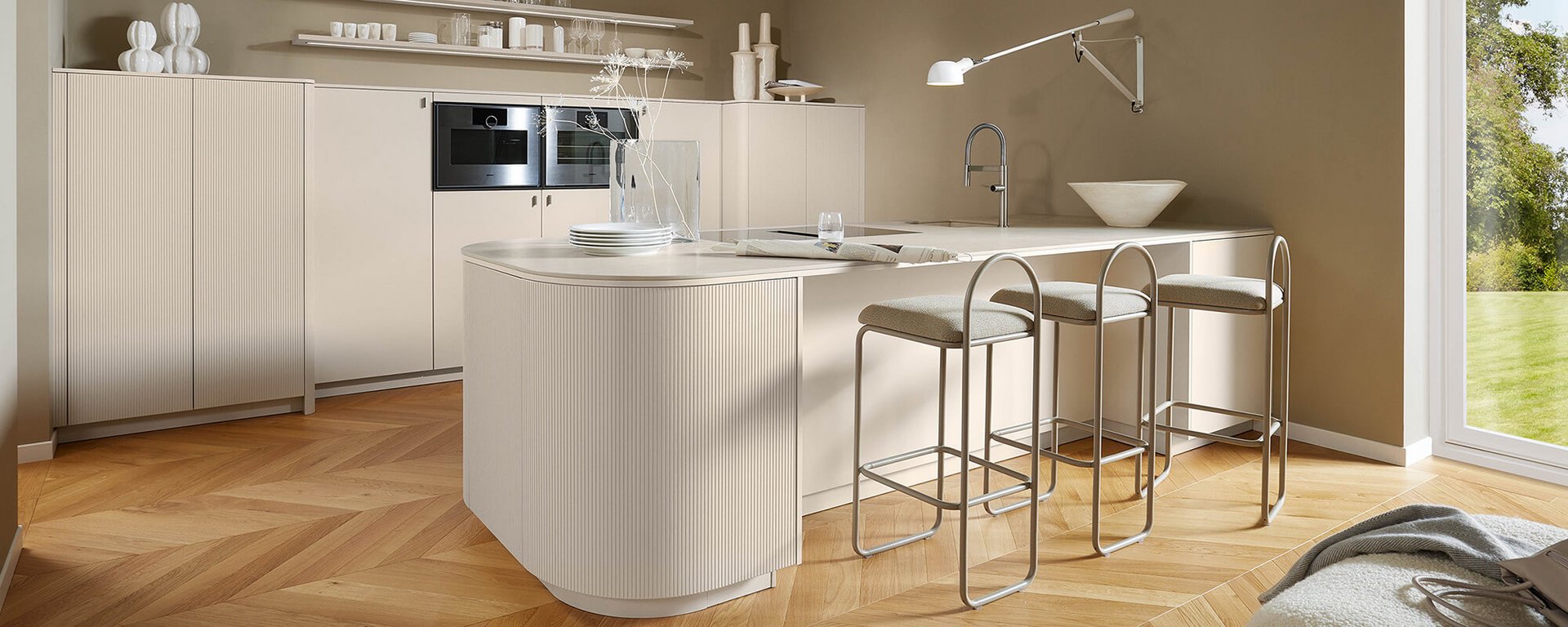 Harmonische Design-Psychologie im Interior Design durch eine strukturierte Kücheninsel mit Rundung für maximales Wohlbefinden.