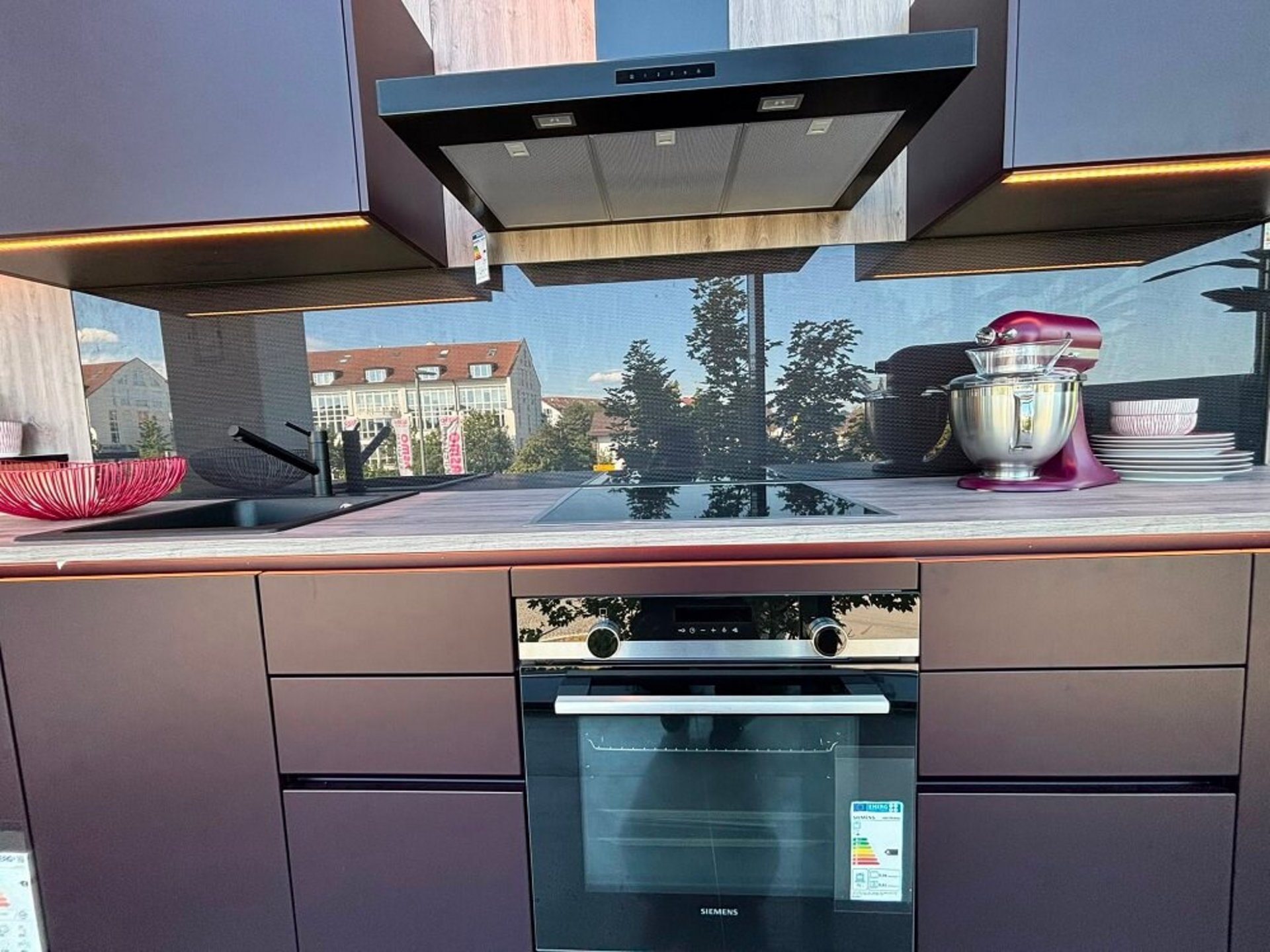 Moderne Küchenzeile mit integriertem Kochbereich, dunklen Fronten und offenem Regalsystem bei ASMO KÜCHEN Unterhaching