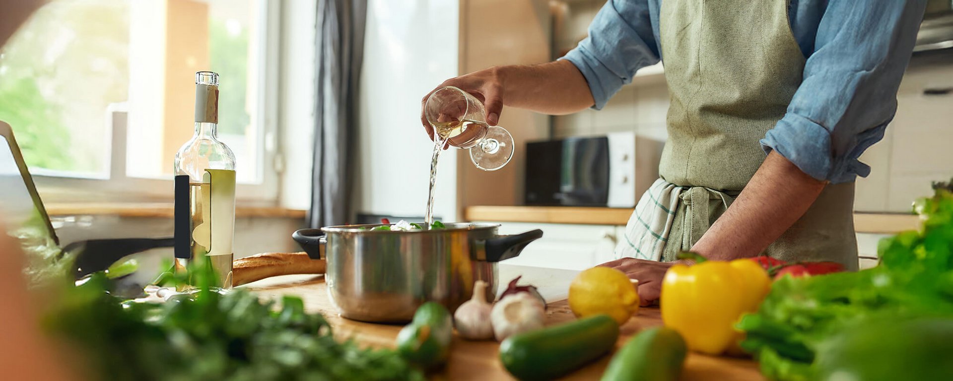 Ein Koch verfeinert ein Gericht mit Weisswein – Wein-zum-Kochen-und-Geniessen.