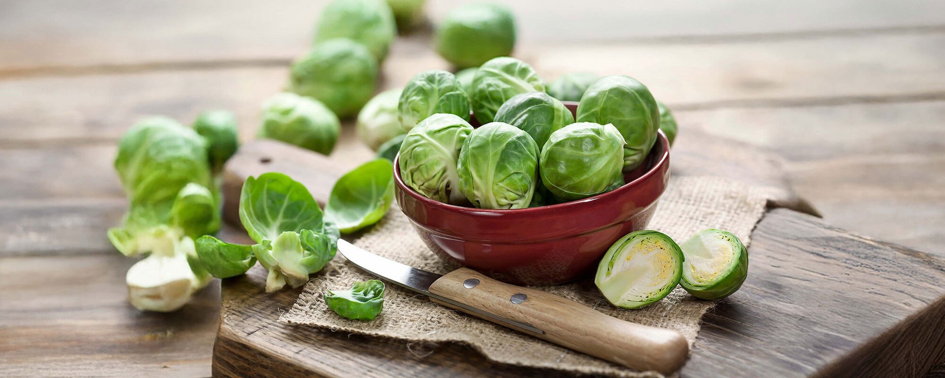 Frischer Rosenkohl und Messer auf Holzbrett – Rosenkohl Gesundheit als natürliche Nahrungsergänzung aus Gemüse