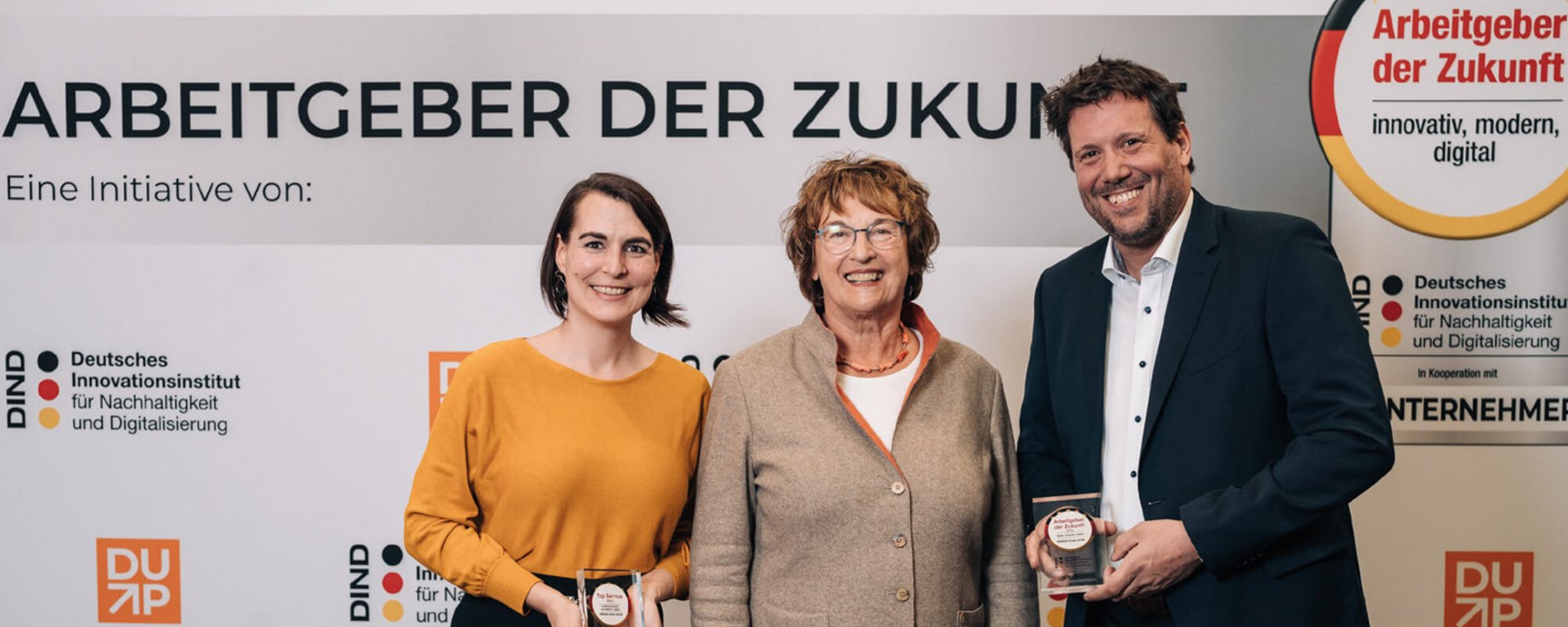 Drei Personen bei der Verleihung der Auszeichnung „Arbeitgeber der Zukunft“