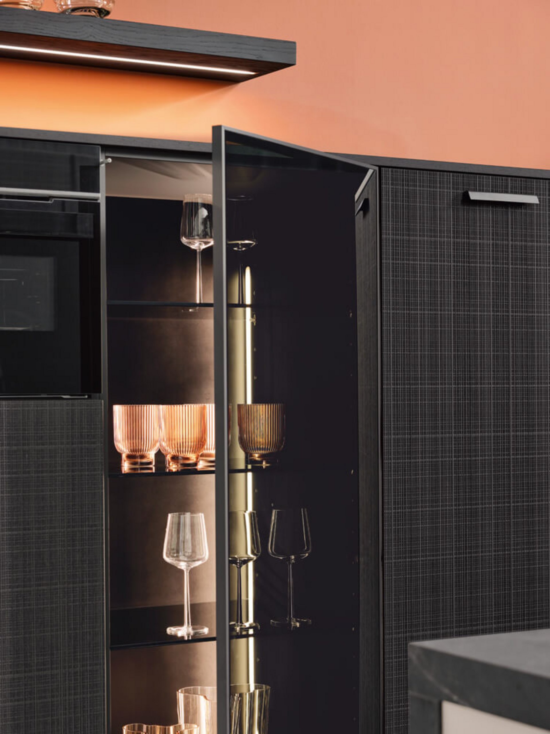 Beleuchteter Vitrinenschrank mit Glasfront und Gläsern im Innenraum