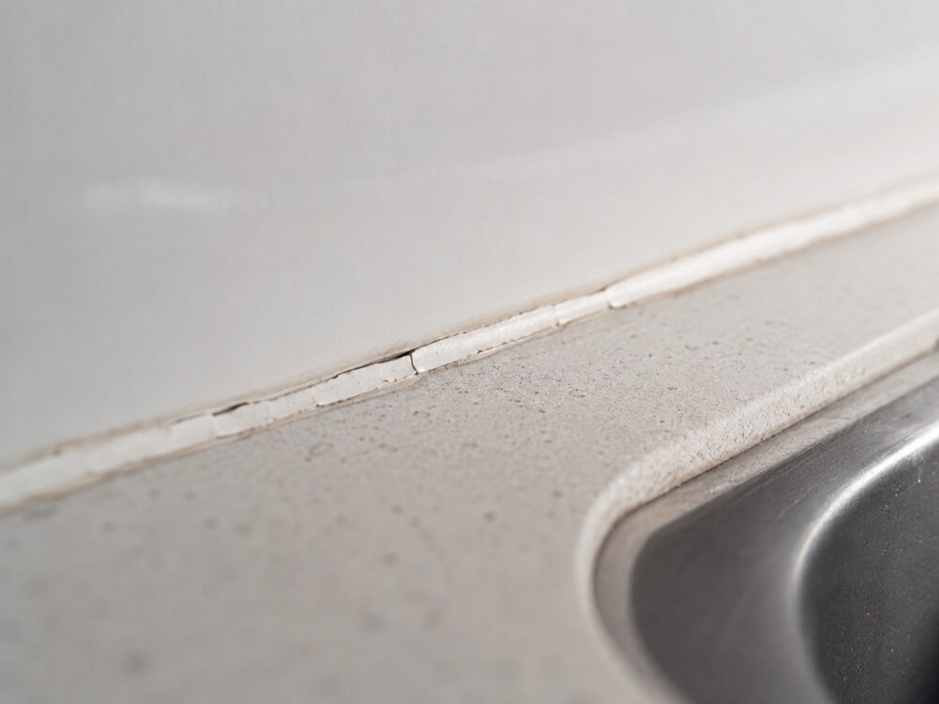 Beschädigte Silikonfuge zwischen Arbeitsplatte und Küchenrückwand