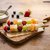Bunte Obstspieße mit verschiedenen frischen Früchten auf einem Holzbrett