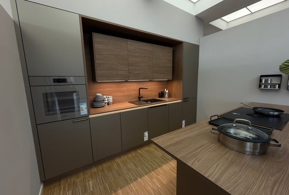 Moderne Küchenzeile in Grau mit Holzrückwand, Einbauofen und Kochinsel