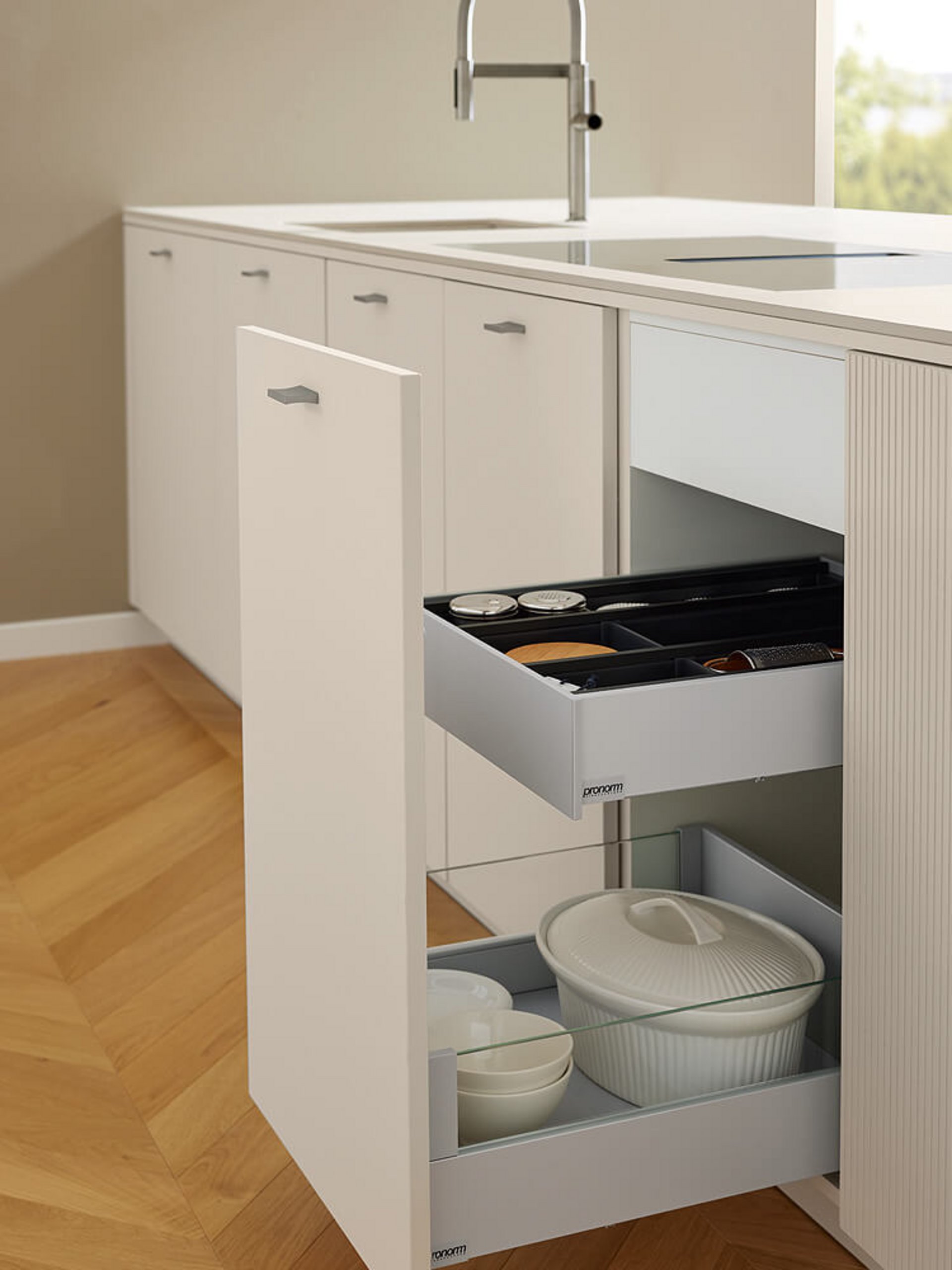 Innovative Stauraumlösung in der grifflosen Küche mit titanfarbenem Auszugssystem und Glaselementen.