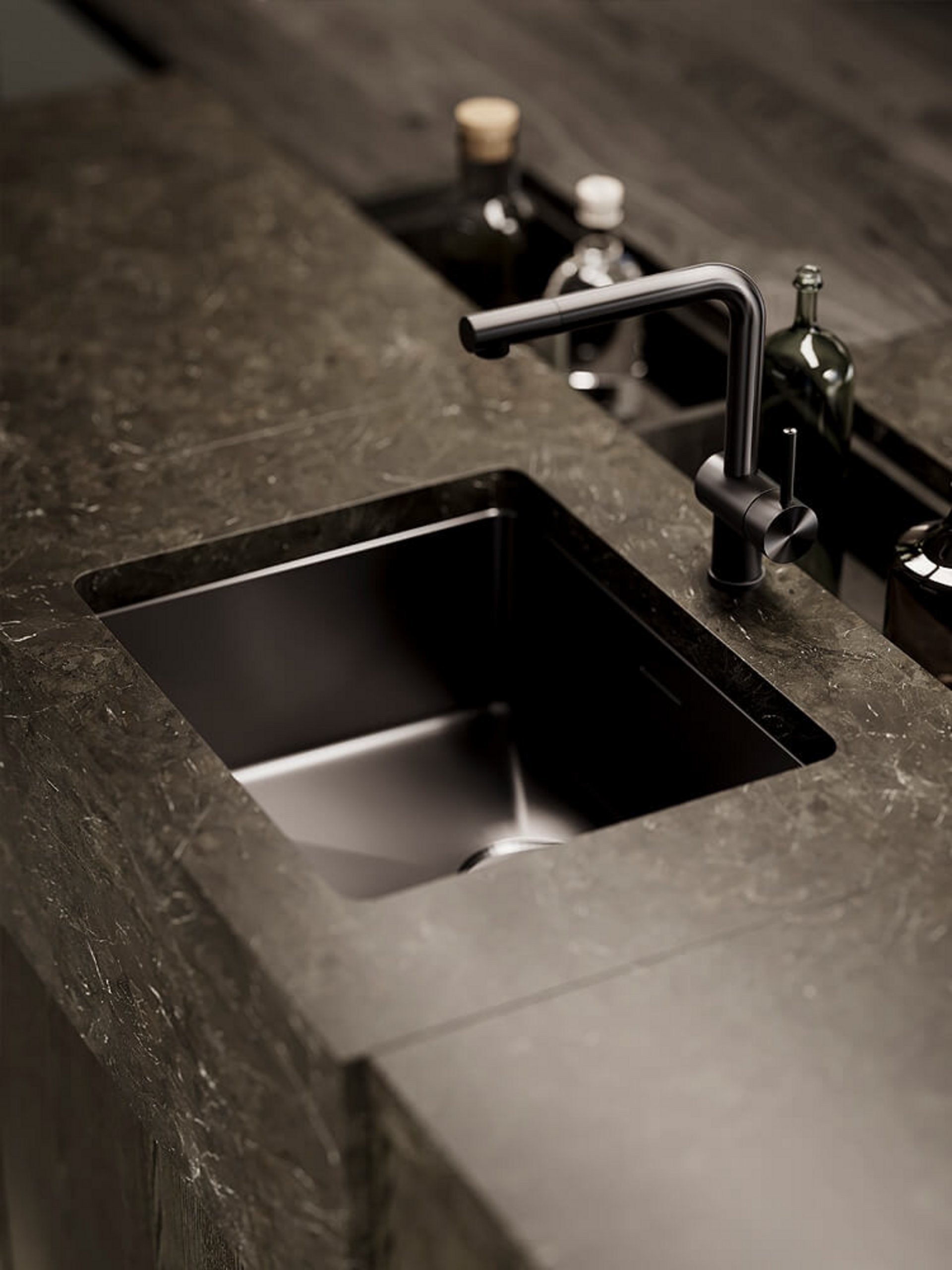 Unterbau-Spüle aus dunklem Edelstahl bündig integriert in braun marmorierte Naturstein-Arbeitsplatte