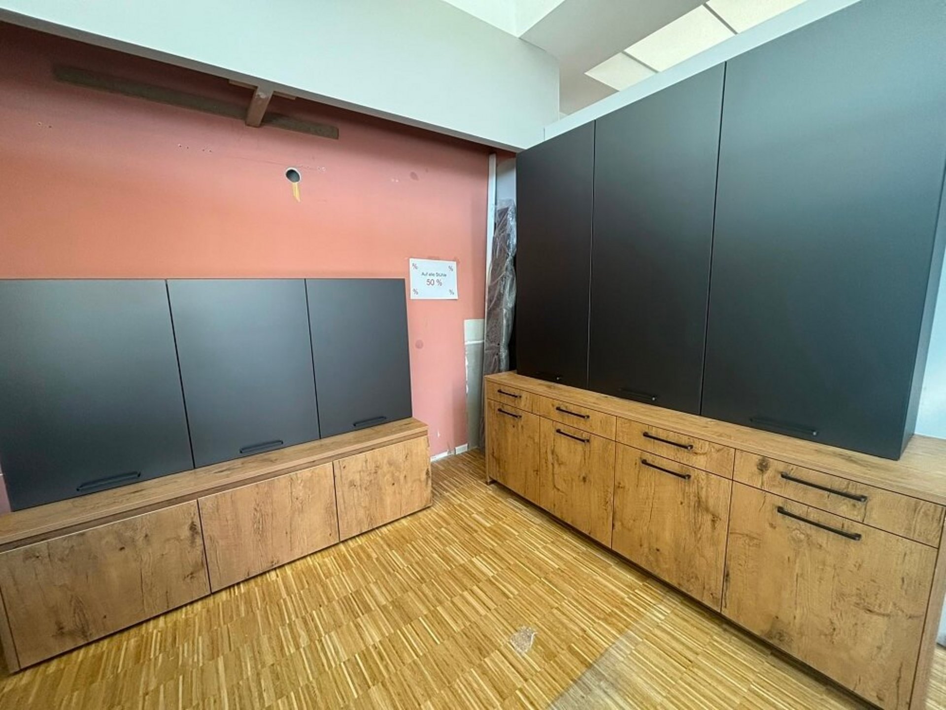 Zweiteiliger Arbeitsplatz mit dunkler Rückwand, Arbeitsfläche und Holzoptik in der ASMO KÜCHEN Ausstellung Unterhaching