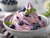 Cremiges Blaubeer-Softeis mit Topping in einer Schale angerichtet