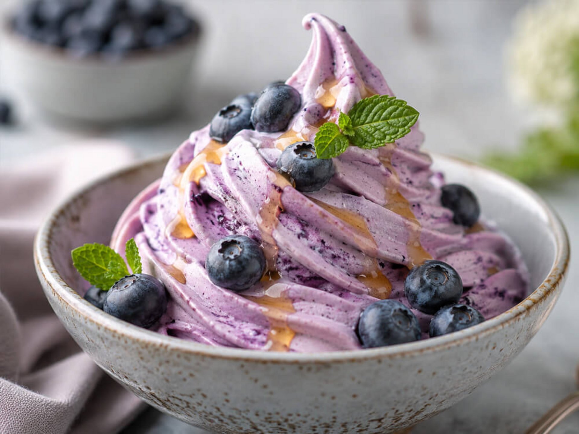 Cremiges Blaubeer-Softeis mit Topping in einer Schale angerichtet