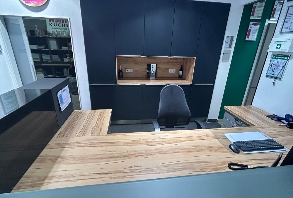 Moderner Arbeitsplatz mit Schreibtisch, Stauraumschränken, Holzoptik und dunklen Fronten bei ASMO KÜCHEN