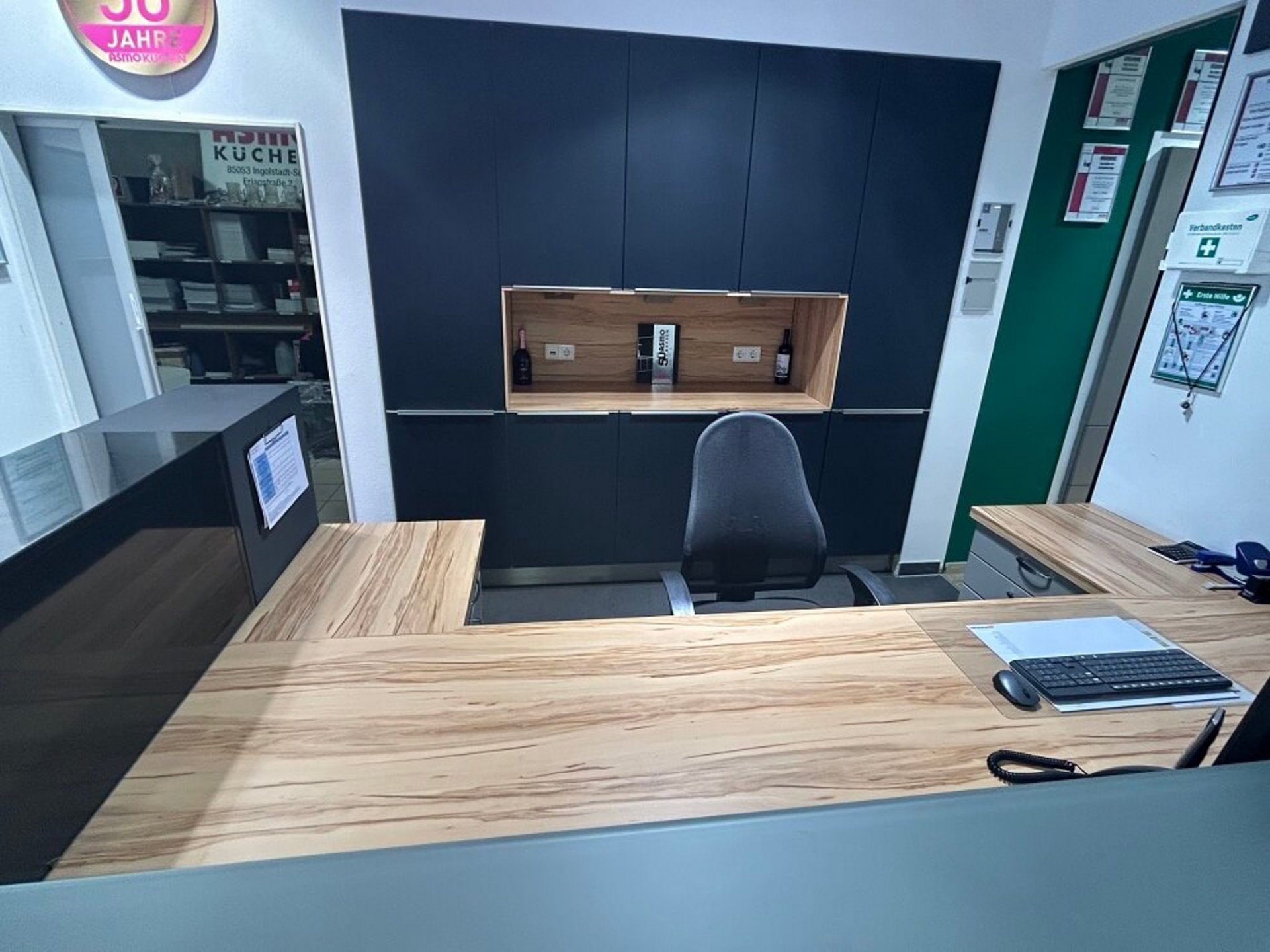 Moderner Arbeitsplatz mit Schreibtisch, Stauraumschränken, Holzoptik und dunklen Fronten bei ASMO KÜCHEN