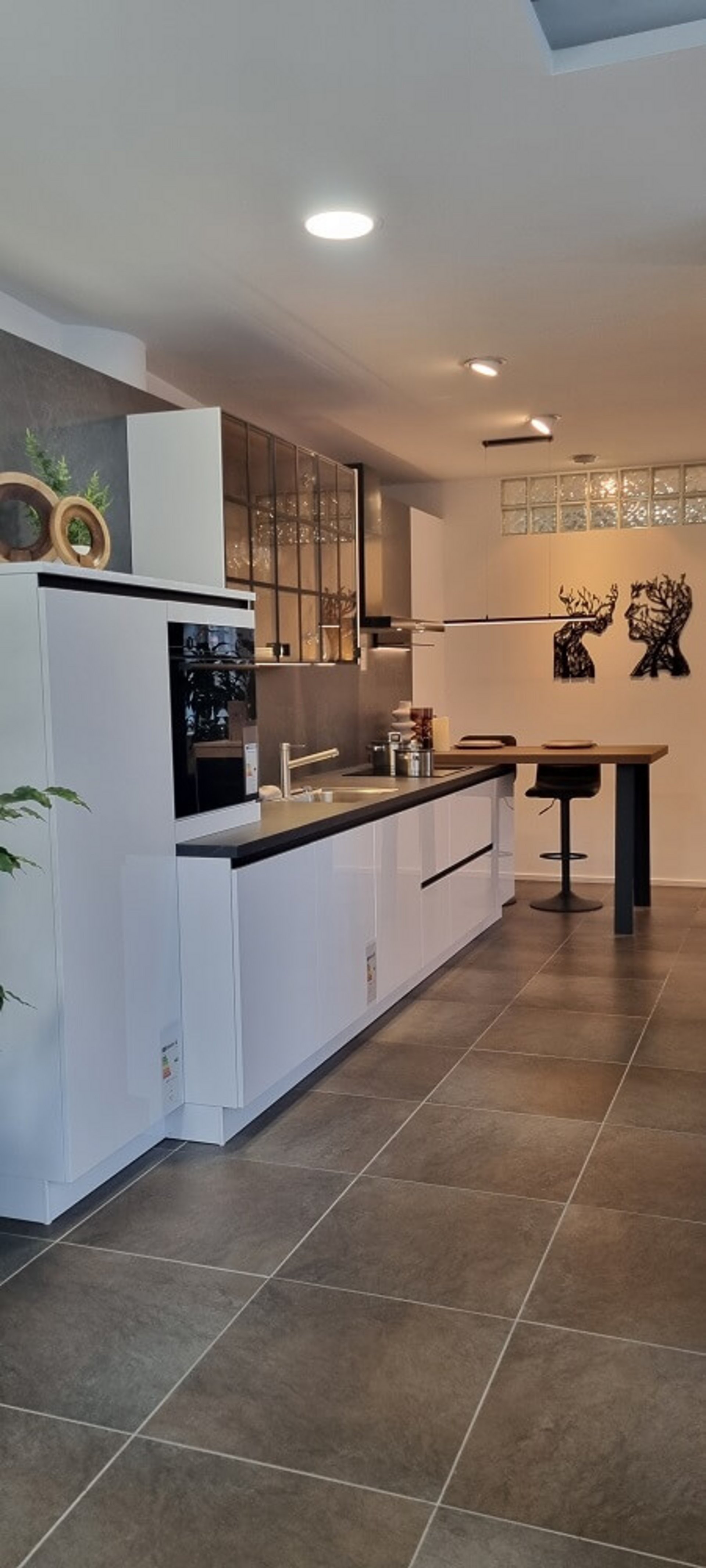 Moderne ASMO X-Line Küchenzeile in Superweiß Hochglanz mit übertiefer Arbeitsplatte und Essplatz in der Ausstellung Landshut, Koje 17N.