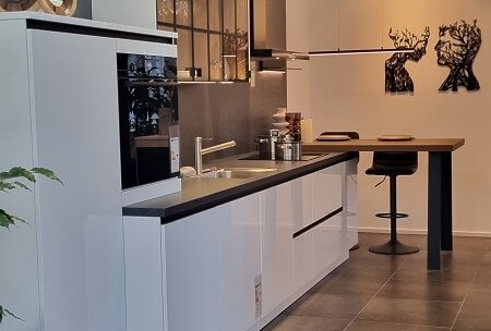 Moderne ASMO X-Line Küchenzeile in Superweiß Hochglanz mit übertiefer Arbeitsplatte und Essplatz in der Ausstellung Landshut, Koje 17N.