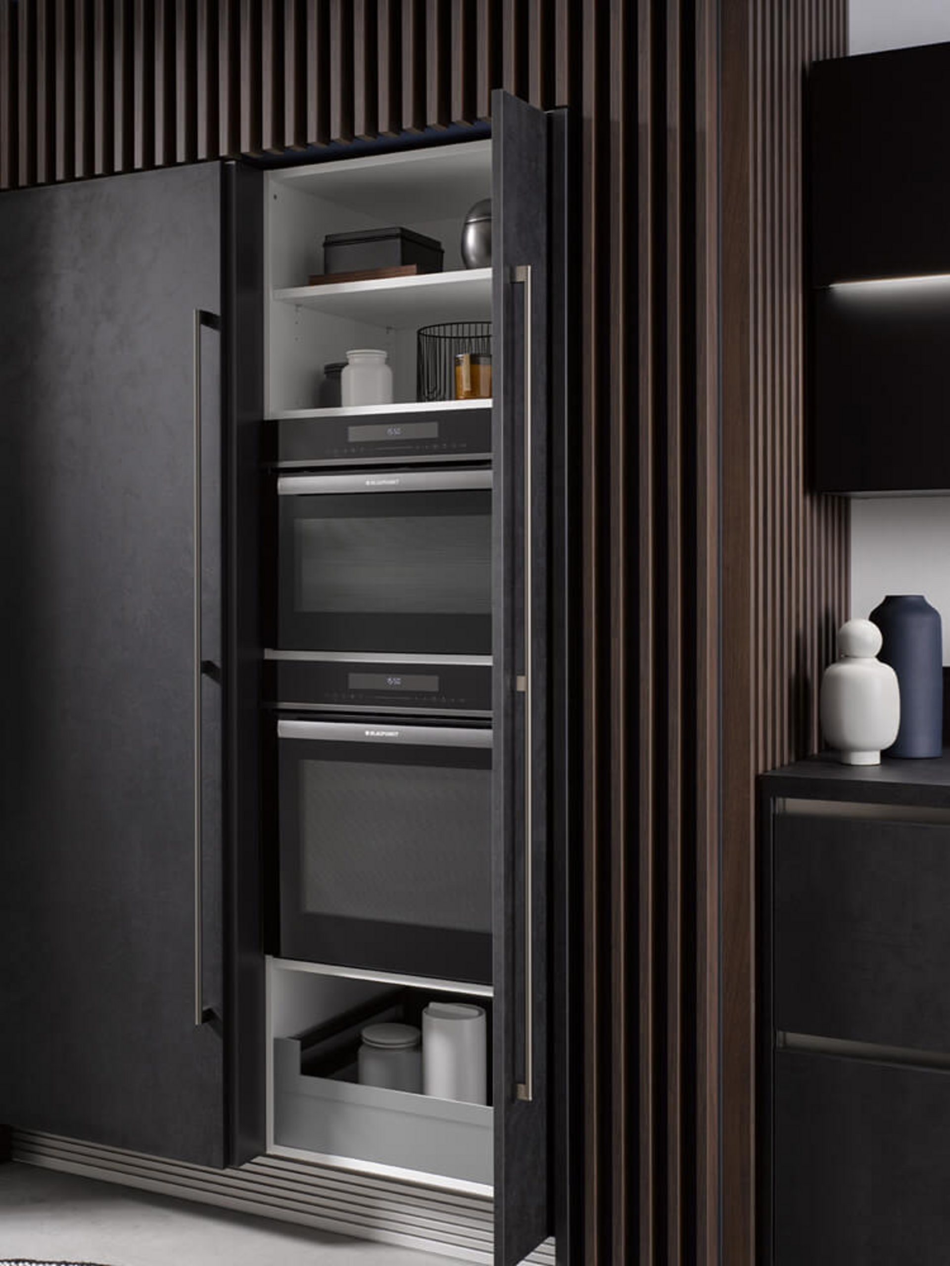 Dunkle Küchenzeile mit geöffneten Pocket Doors und integriertem Stauraum