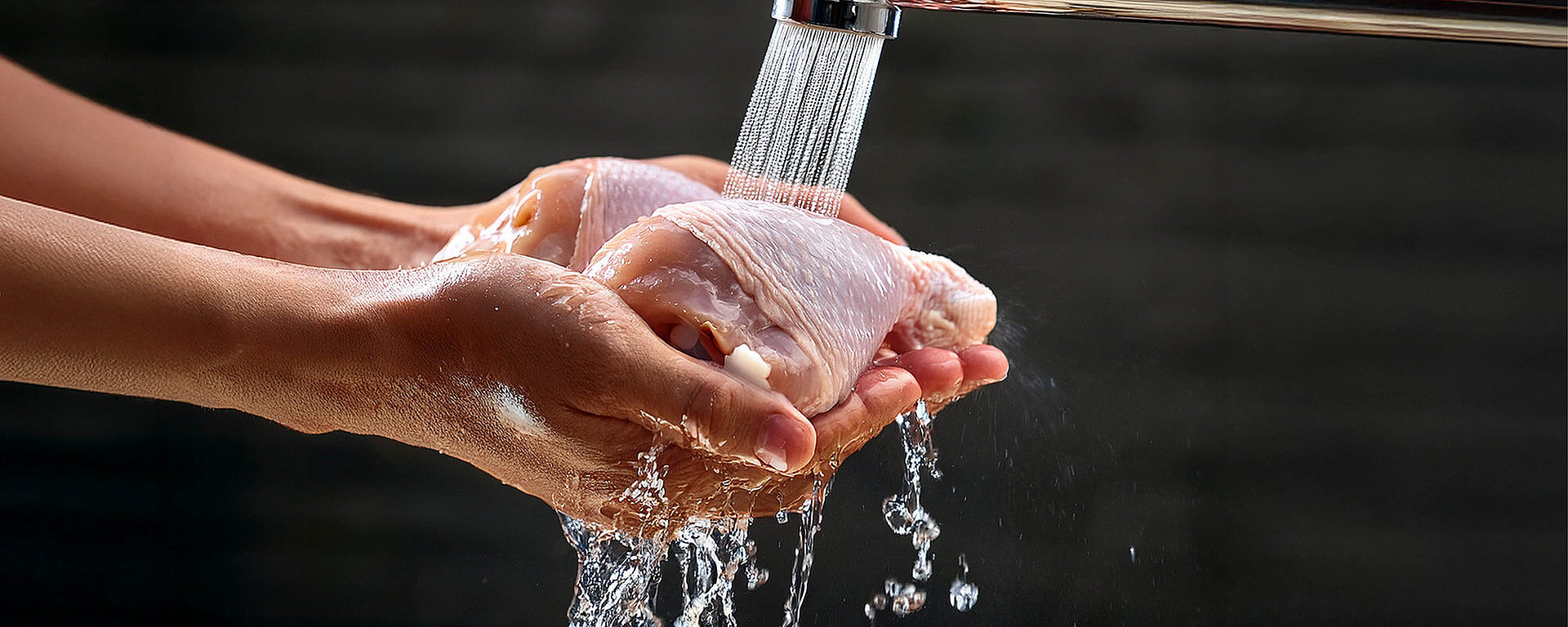 Hände unter fließendem Wasser nach Kontakt mit rohem Hähnchen waschen