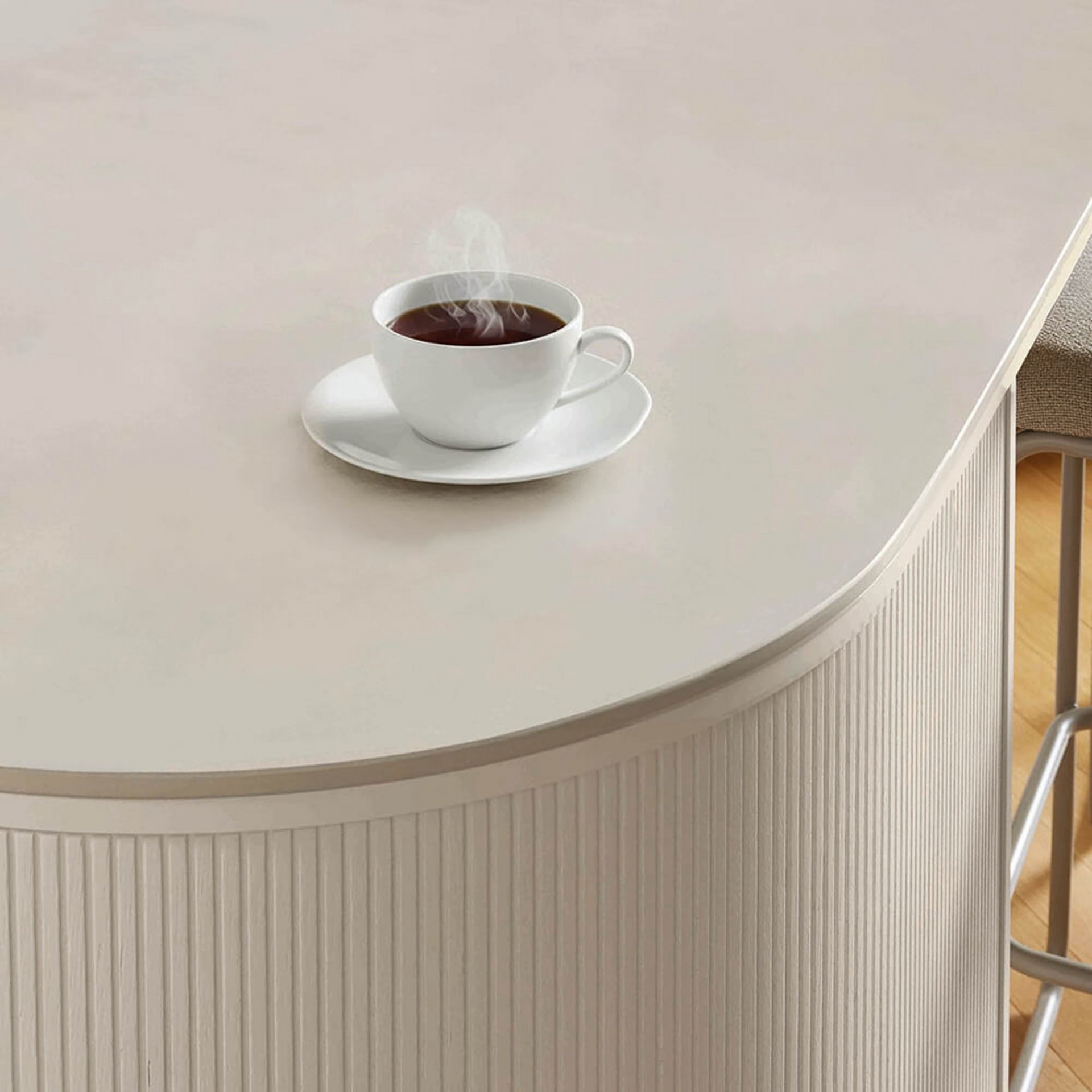 Runde helle Kücheninsel mit geriffelter Front und Tasse auf der Arbeitsfläche – nordischer Stil in warmen Naturtönen